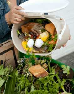 pouring food scraps into compost bin