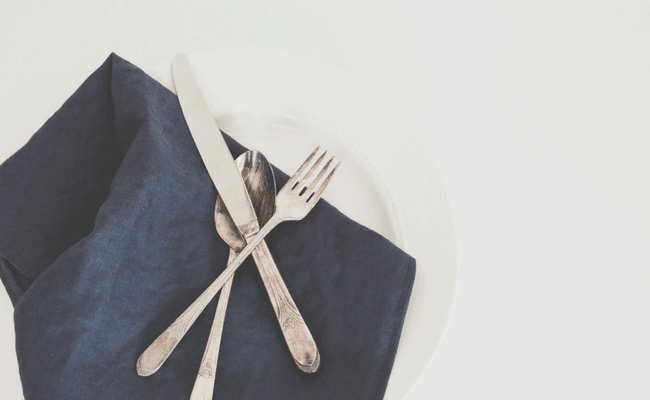 set of silverware on a dark blue napkin